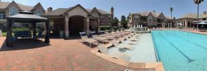 Apartments in West Houston, Texas - Community Pool with Tanning Shelf, Lounge Chairs and Covered Seating