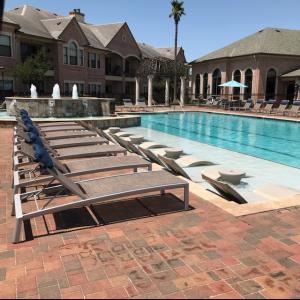Apartments in West Houston, Texas - Community Pool with Tanning Shelf and Lounge Chairs